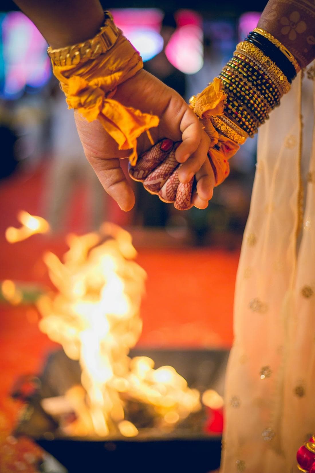 The couple's joined hands above the sacred fire